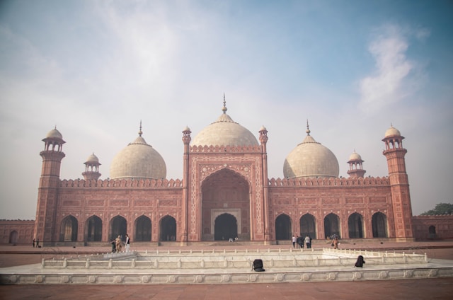 Badshahi Mosque with domes and people in front of it